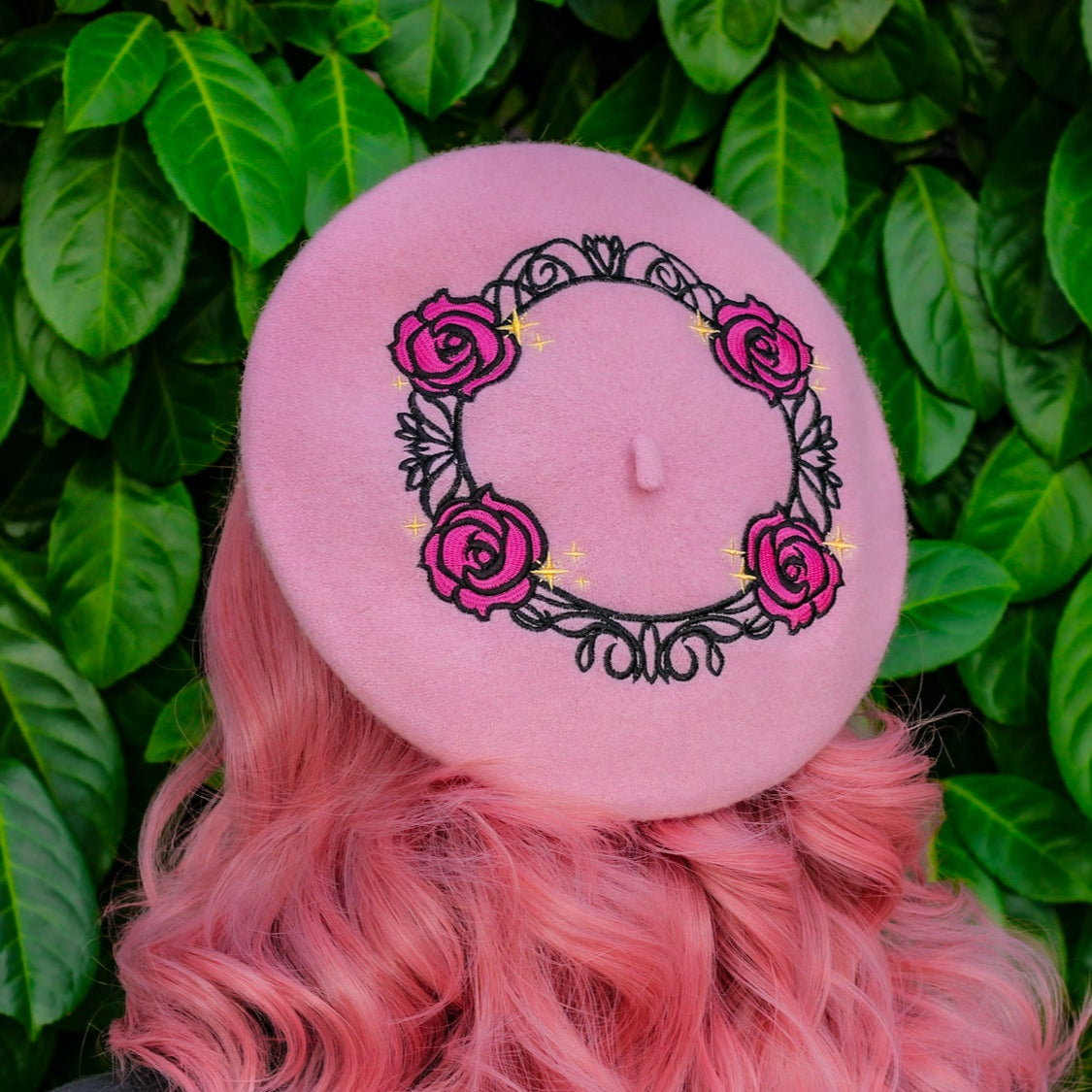 Person with pink hair holding a white flower against a green leafy background